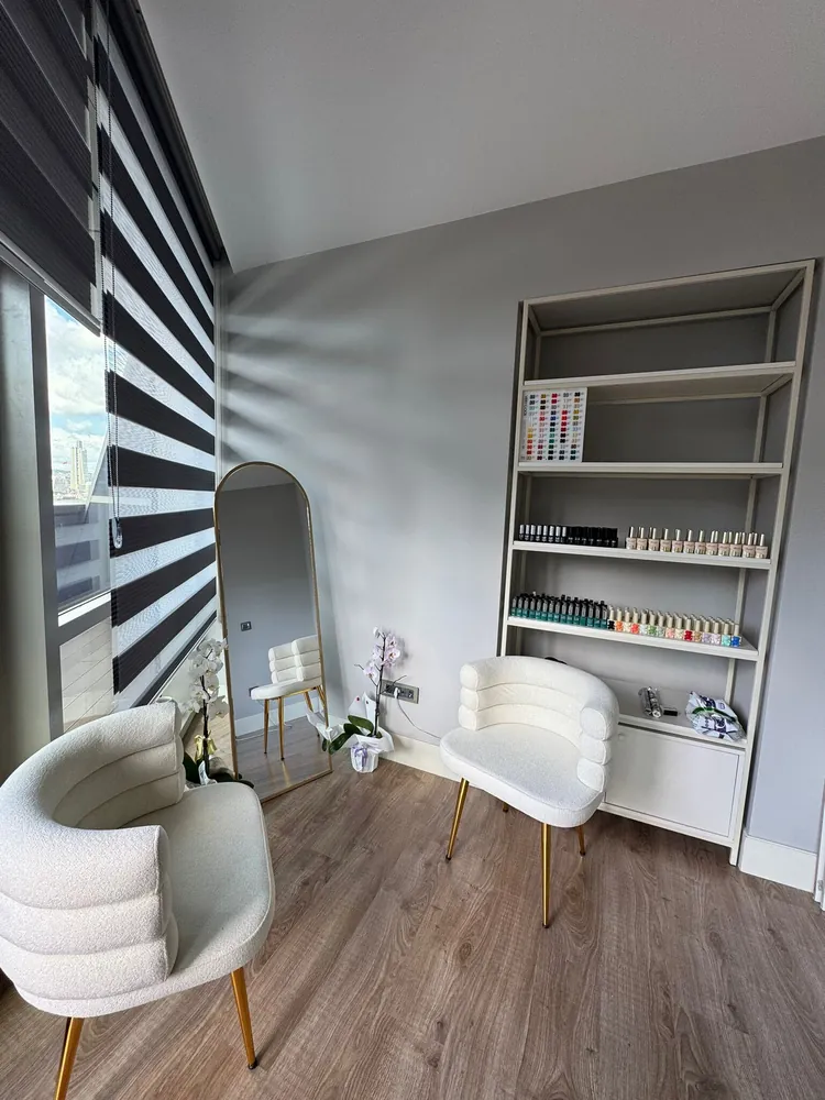 Nailnissbar salon içi – bukle koltuklar, altın detaylar ve oje rafı